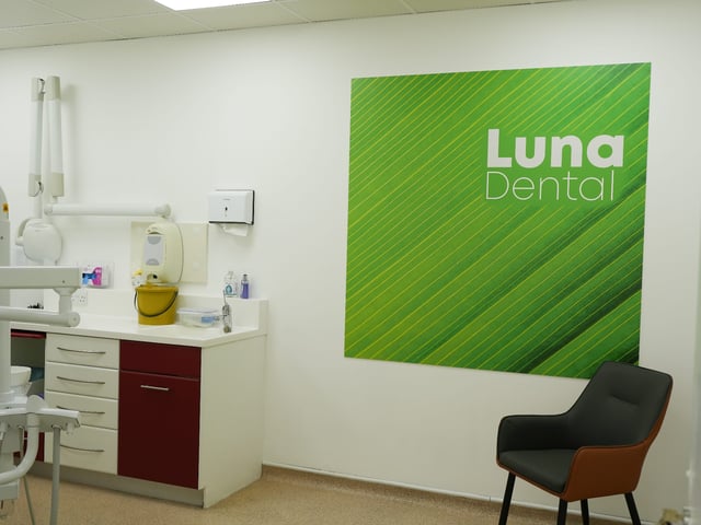 A Luna Dental treatment room with worktop, sink and branded wall panel
