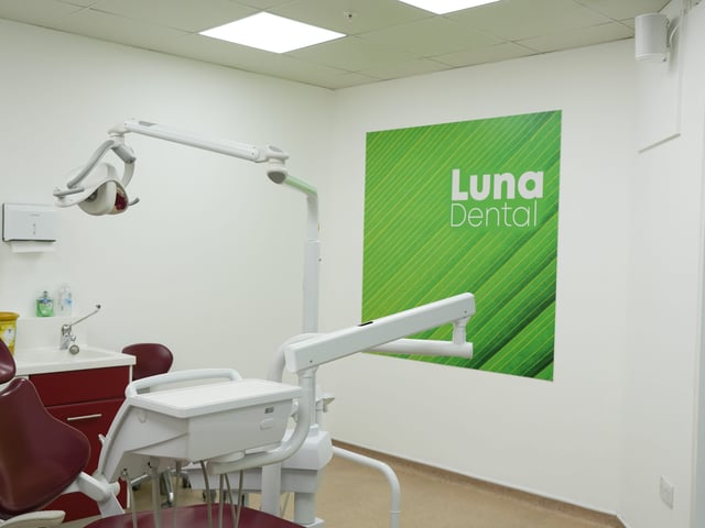 A Luna Dental surgery with green branded wall artwork